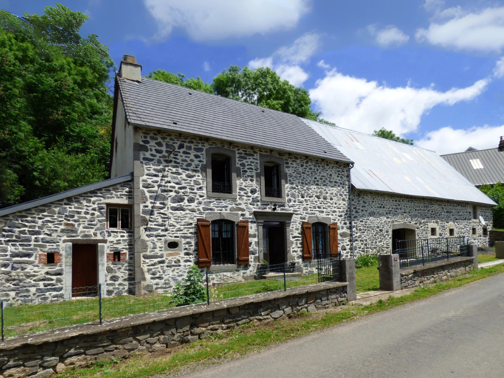 Devanture d'une maison en pierre apparente, à la campagne